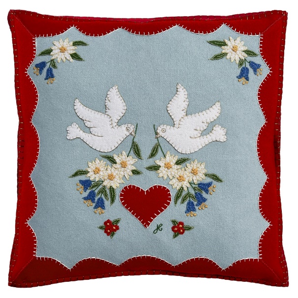 A pillow with a heart and birds on it

Description automatically generated